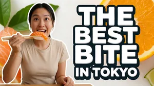 A flat, straight-on YouTube thumbnail. A food vlogger mid-reaction on the left third, delighted and holding chopsticks lifting a glistening piece of salmon nigiri toward her mouth. On the right two-thirds, stacked thumbnail text in chunky bold white letters with a thick dark outline: a large top line "THE BEST BITE" and a smaller sub text line beneath it "IN TOKYO." Clean bright palette — fresh oranges, greens, white and cream with soft natural light. High-contrast food-vlogger thumbnail style, crisp detail, no tilt, no 3D perspective.