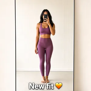 A lifestyle fashion selfie post, straight-on and flat. A stylish woman taking a mirror-fit selfie with her phone covering part of her face, wearing a trendy yoga outfit, standing in a bright minimal room. a one-line text at bottom "New fit ♥️ " Clean, bright, high-contrast social-media aesthetic, crisp detail, no tilt, no 3D perspective.